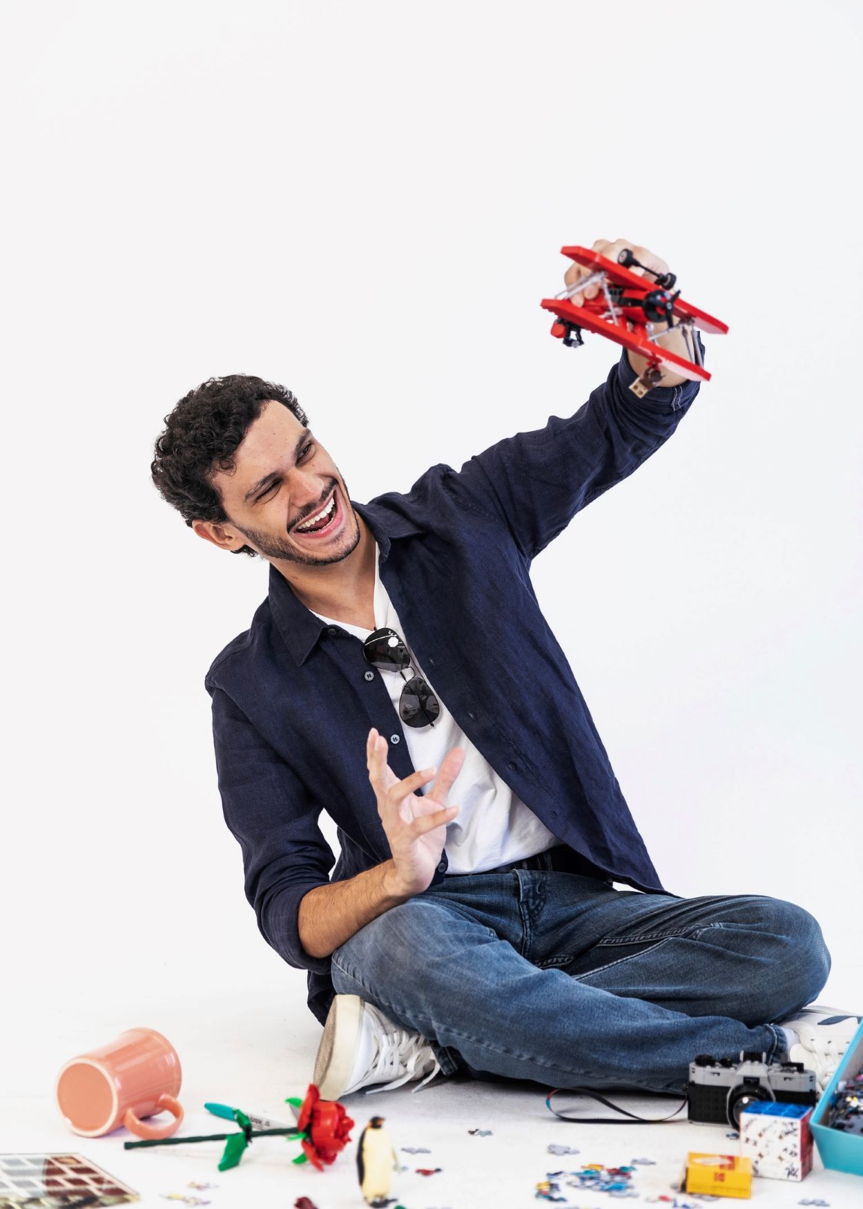 Bryan sitting and joyfully playing with a lego biplane